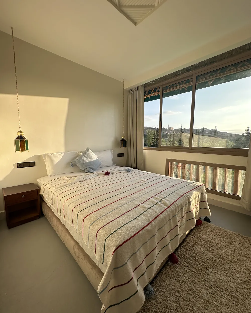 Bedroom opening onto a balcony with a view over the valley